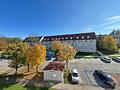 Moderne 5-Zimmer-Wohnung in idyllischer Grünlage – sofort bezugsfrei - Blick zur Hauszufahrt mit den Parkplätzen und dem Müllhaus
